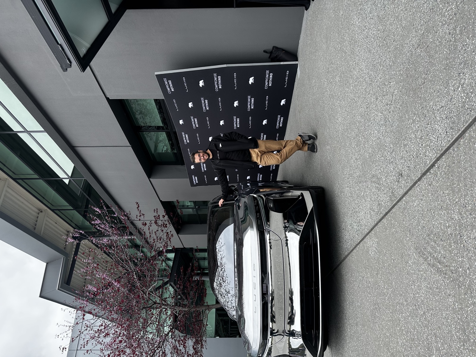 Travis Cournoyer standing beside a Lucid vehicle display.